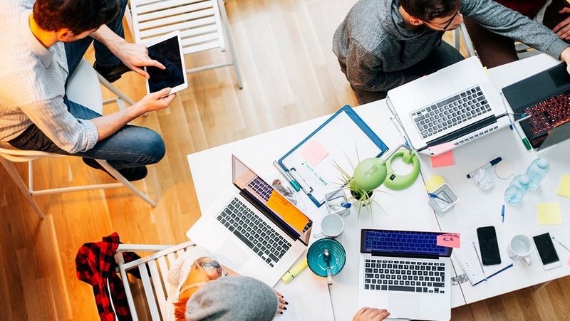 Top down shot of three males in a casual work station
